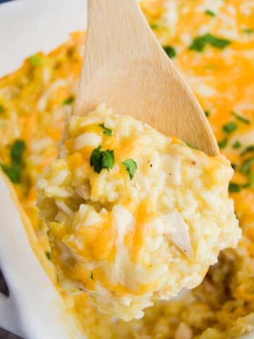 using a spoon to scoop out chicken and rice casserole