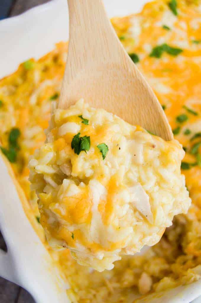 using a spoon to scoop out chicken and rice casserole