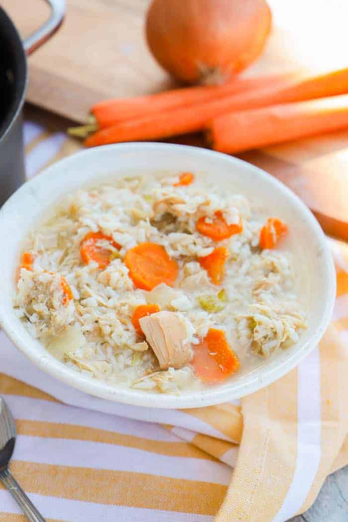 Crock-Pot Chicken and Rice Soup in a white bowl on yellow napkin