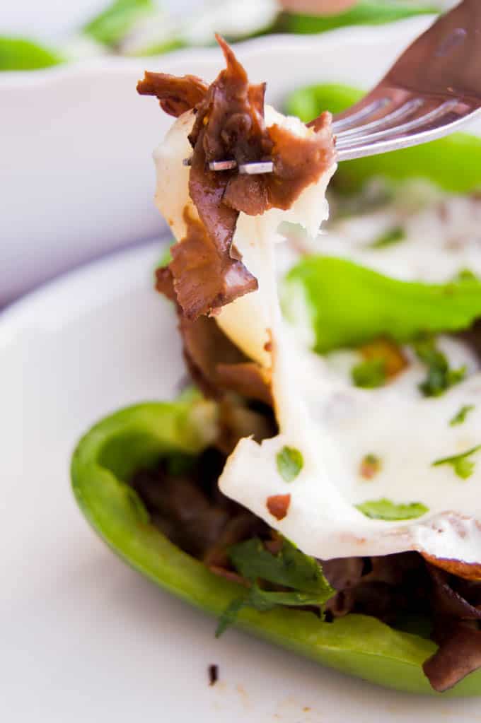 using a fork to grab a bite of the stuffed peppers.