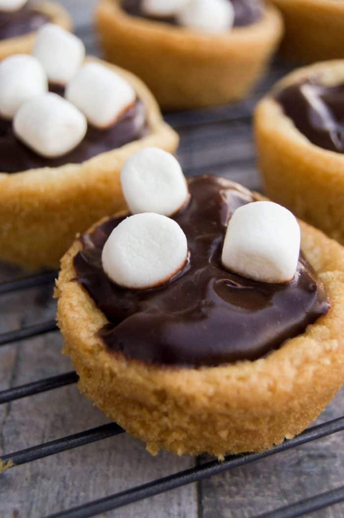 Close-up of Hot Chocolate cookie cups with marshmallows on top, on wire rack