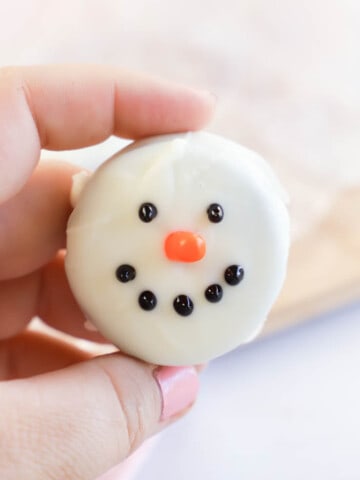 holding Snowmen Oreo Cookie in hand
