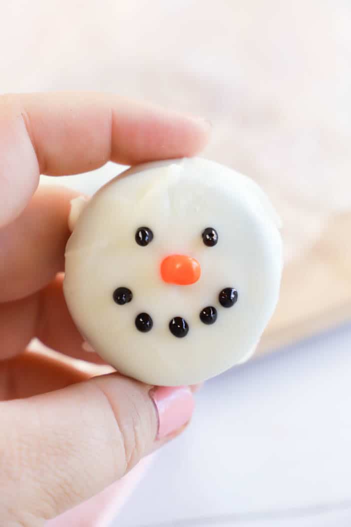 holding Snowmen Oreo Cookie in hand