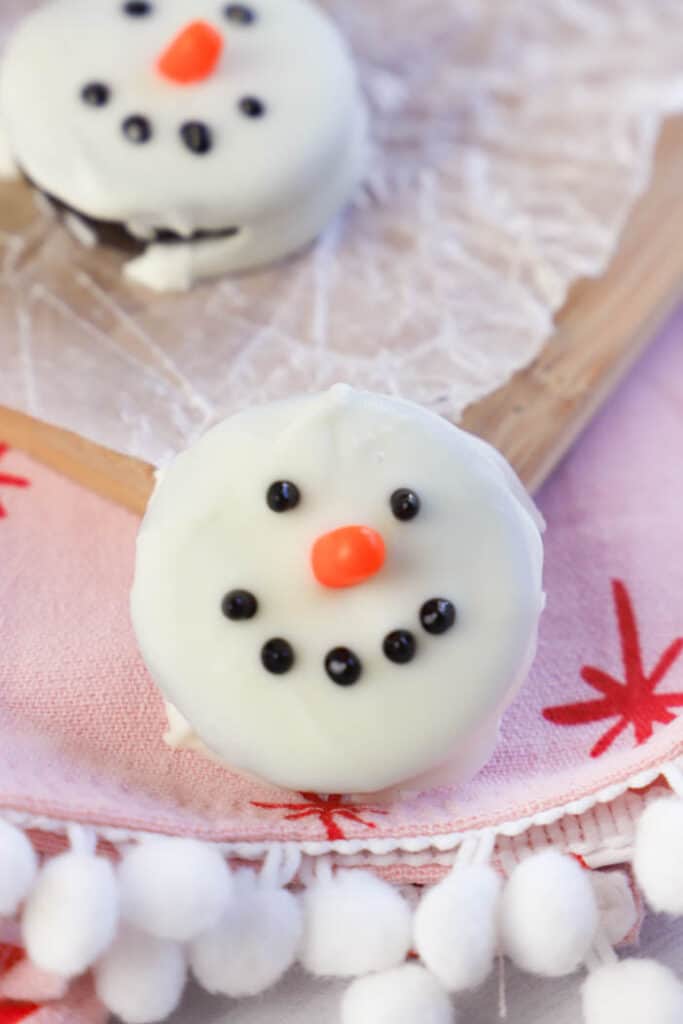 Snowmen Oreo Cookie on a red cloth napkin.