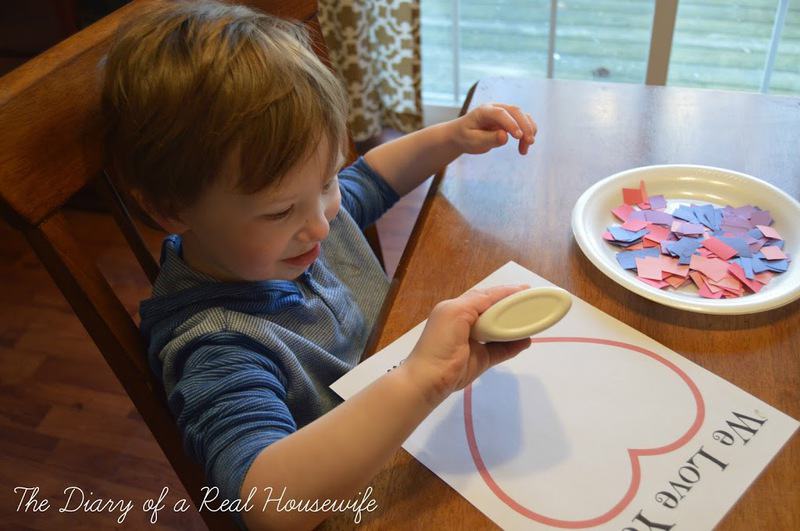 Little boy putting clue on the craft printout at a table