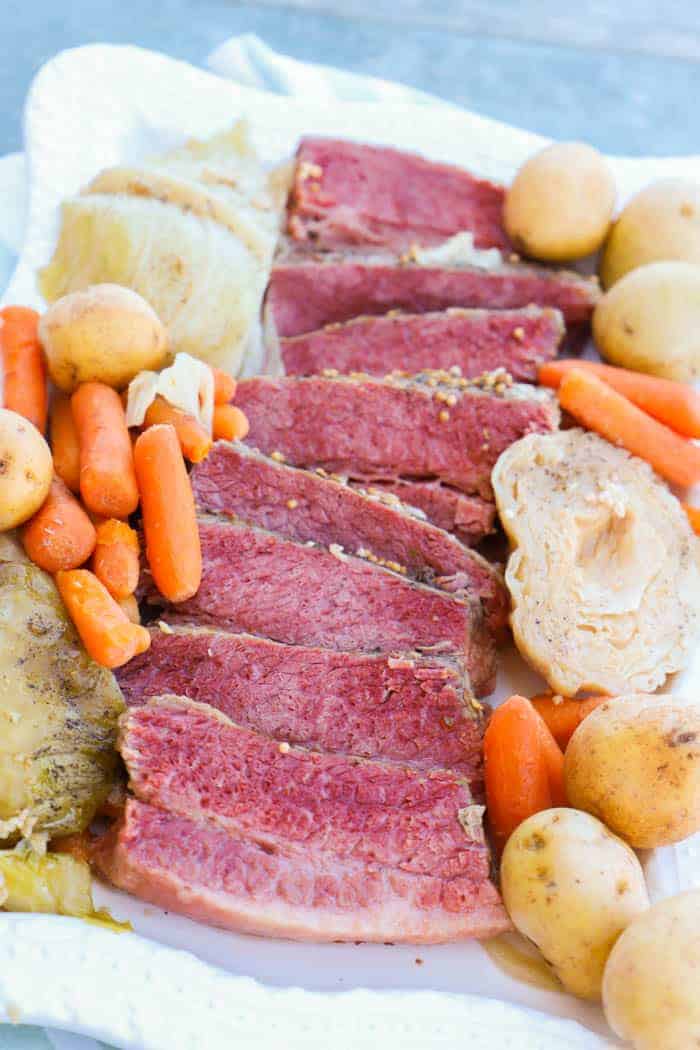 Slow Cooker Corned Beef and Cabbage on white platter with carrots and potatoes