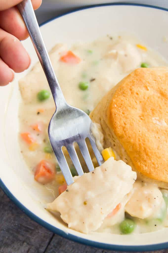 scooping the casserole out of the bowl with a fork