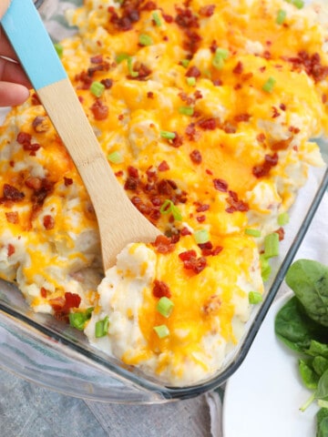 Loaded Baked Potato Casserole with a wooden spoon