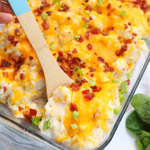 Loaded Baked Potato Casserole with a wooden spoon