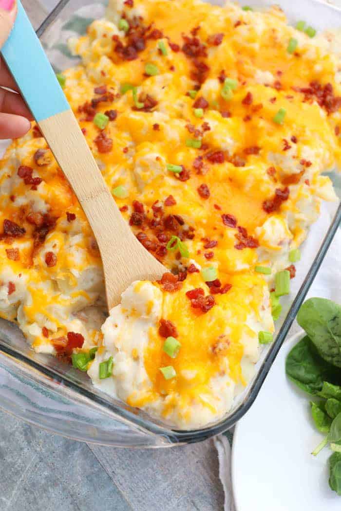 Loaded Baked Potato Casserole being served with a wooden spoon.