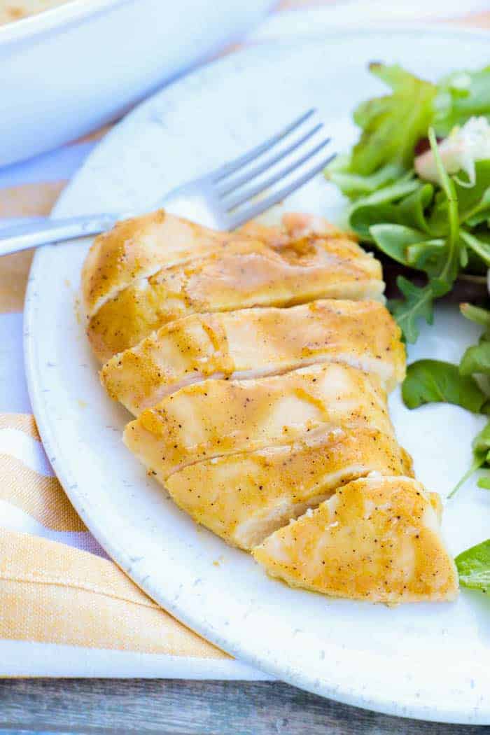 Baked Honey Dijon Chicken on white plate with salad