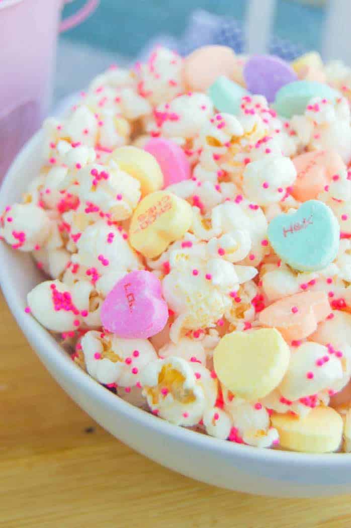 Closeup shot of Valentine's Day Popcorn with heart candies and sprinkles in a white bowl