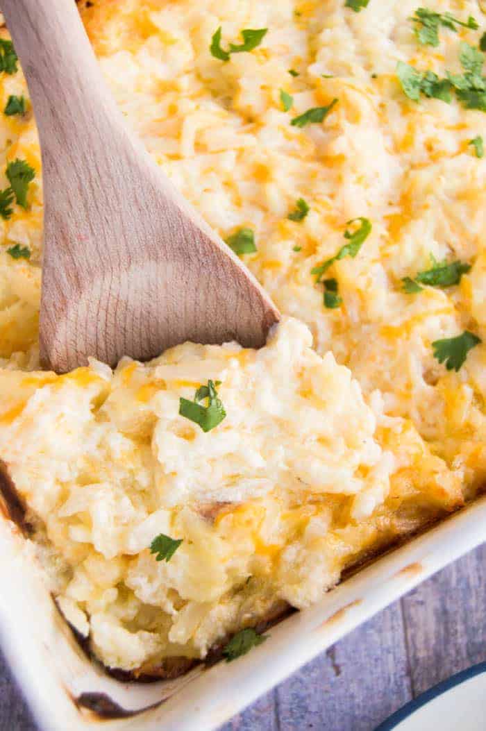 Cracker Barrel Hashbrown Casserole with a wooden spoon