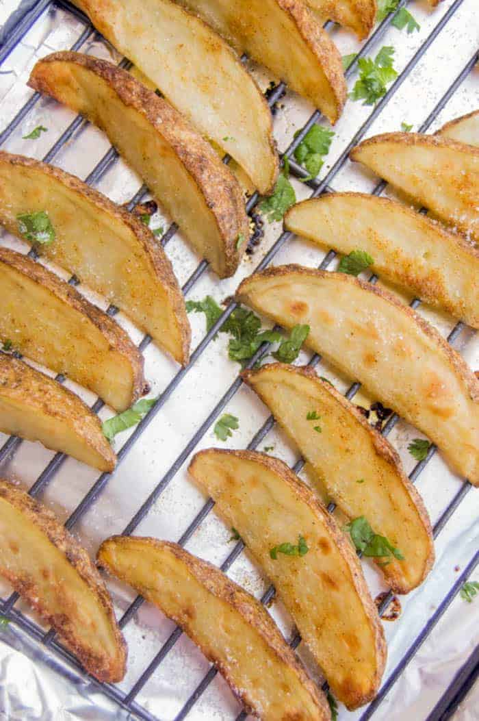 Crispy Potato Wedges on a baking sheet on a wire rack.