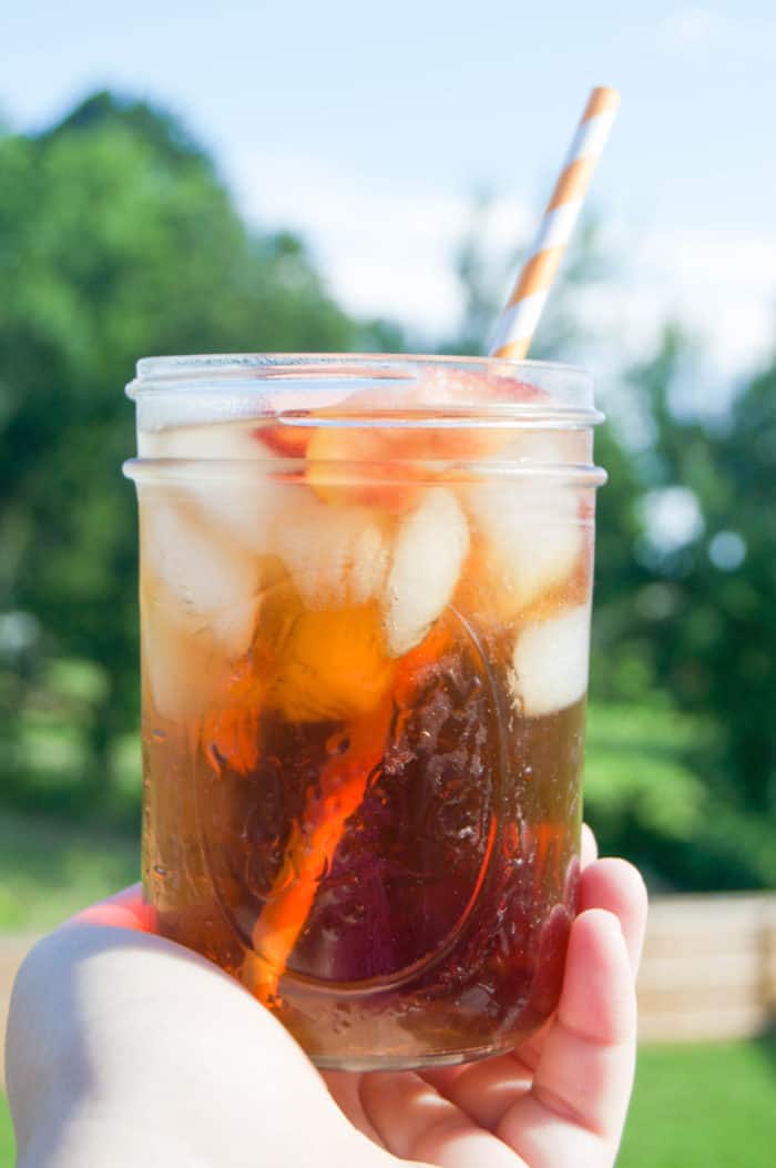 Peach Sweet Tea in hand with straw.