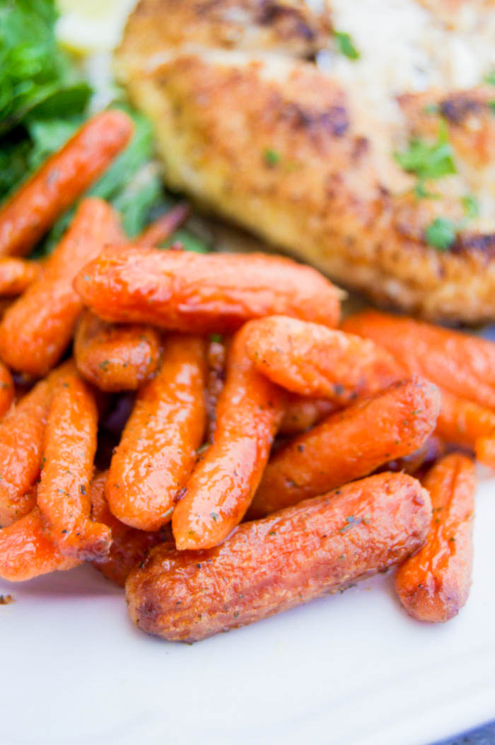 Roasted Ranch Carrots close up with chicken in background and salad