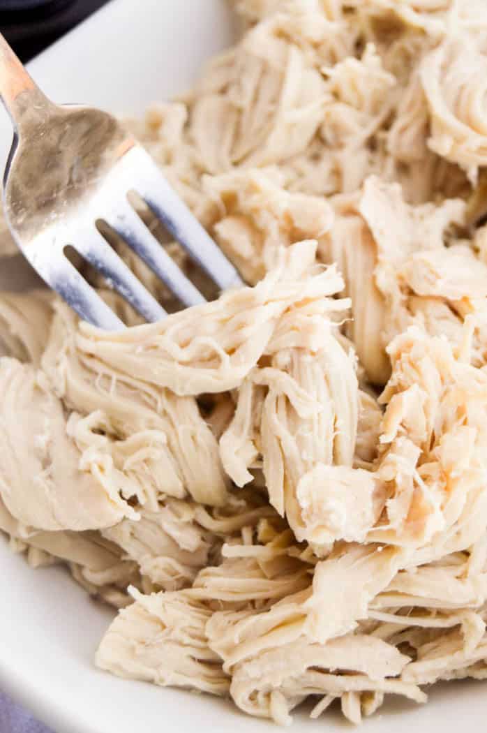 All Purpose Slow Cooker Chicken closeup with fork piercing the chicken