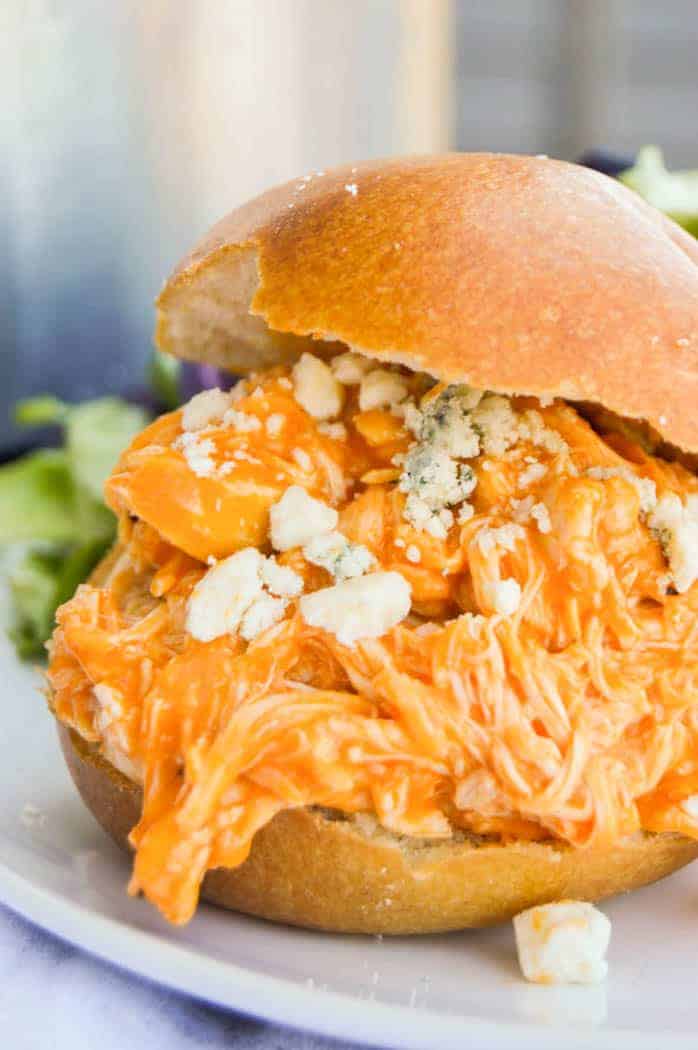 Slow Cooker Buffalo Chicken Sliders on white plate with salad
