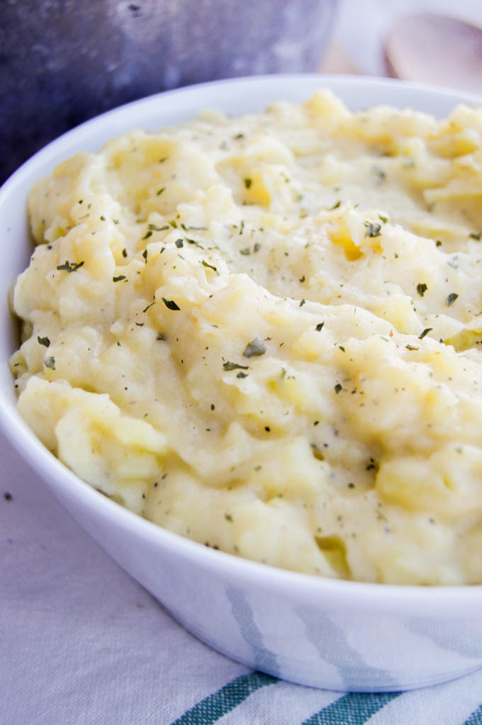 Skinny Mashed Potatoes in a bowl with a wooden spoon on striped towel