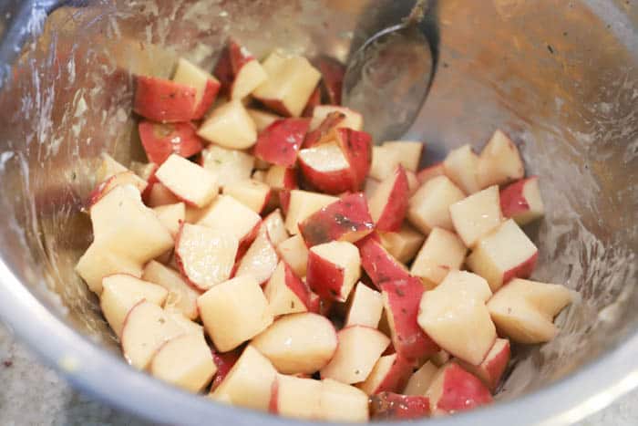 making Slow Cooker Cheesy Ranch Potatoes in a metal bowl