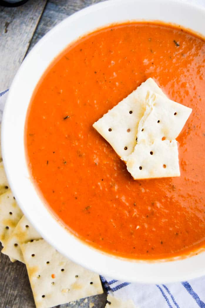 Slow Cooker Tomato Soup in a white bowl with crackers