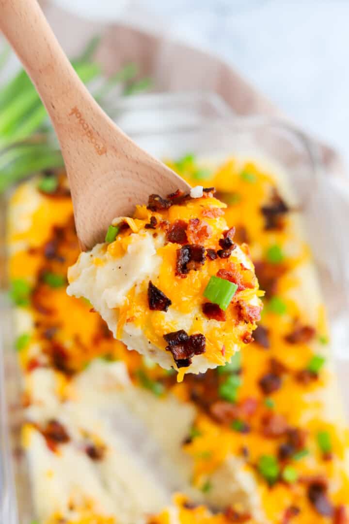 Loaded Mashed Potatoes being scooped with wooden spoon.