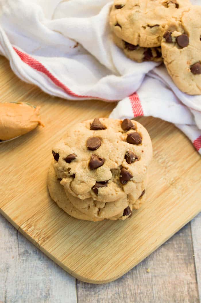 Peanut Butter Chocolate Chip Cookie stacked on wooden board with white towel