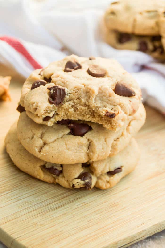 Peanut Butter Chocolate Chip Cookie stacked on wooden board with white towel