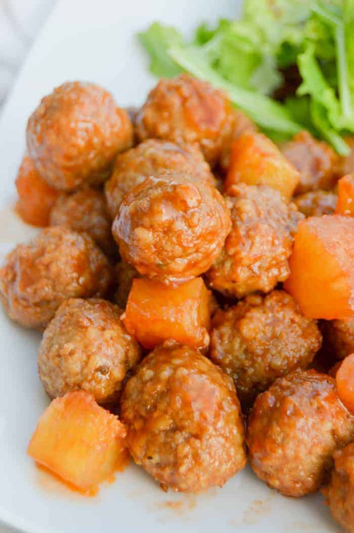 Pineapple BBQ Meatballs on white plate with salad