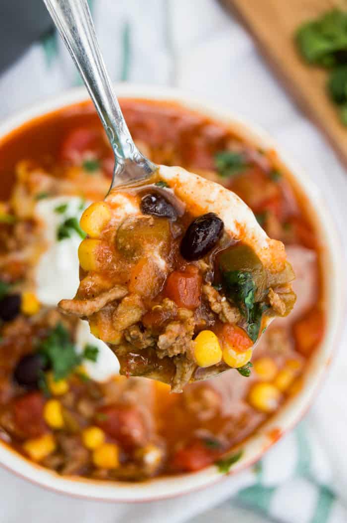 Top Down view of taco Soup in Bowl with spoonful of soup lifted up