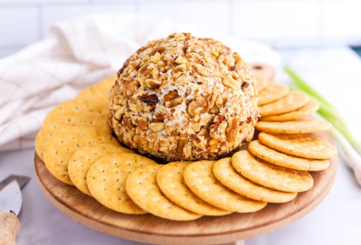 bacon ranch cheeseball on a wooden plate with crackers