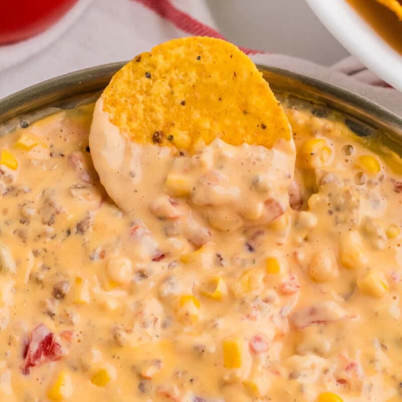 sausage cream cheese dip close up picture with a chip dipped in
