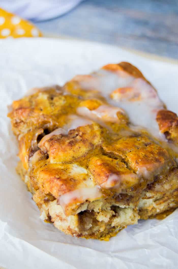 Closeup of Pumpkin Cinnamon Roll Casserole slice on white paper