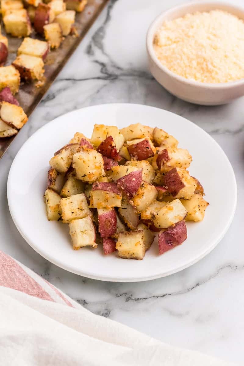 serving roasted potatoes on a white plate