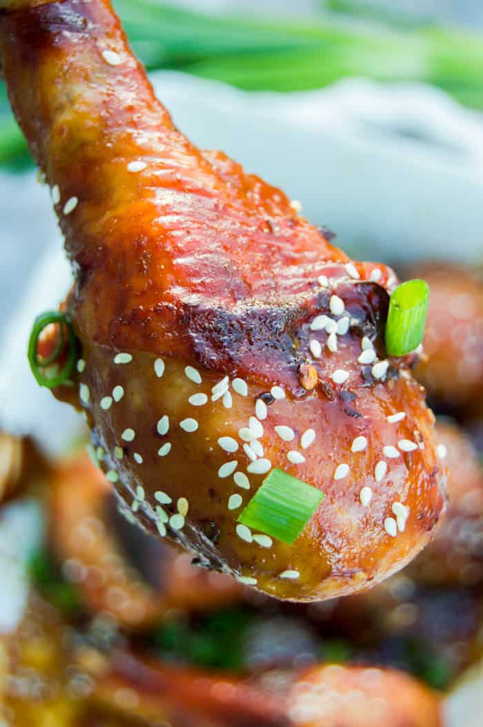 Asian Chicken Drumsticks closeup garnished with sesame seeds and green onions