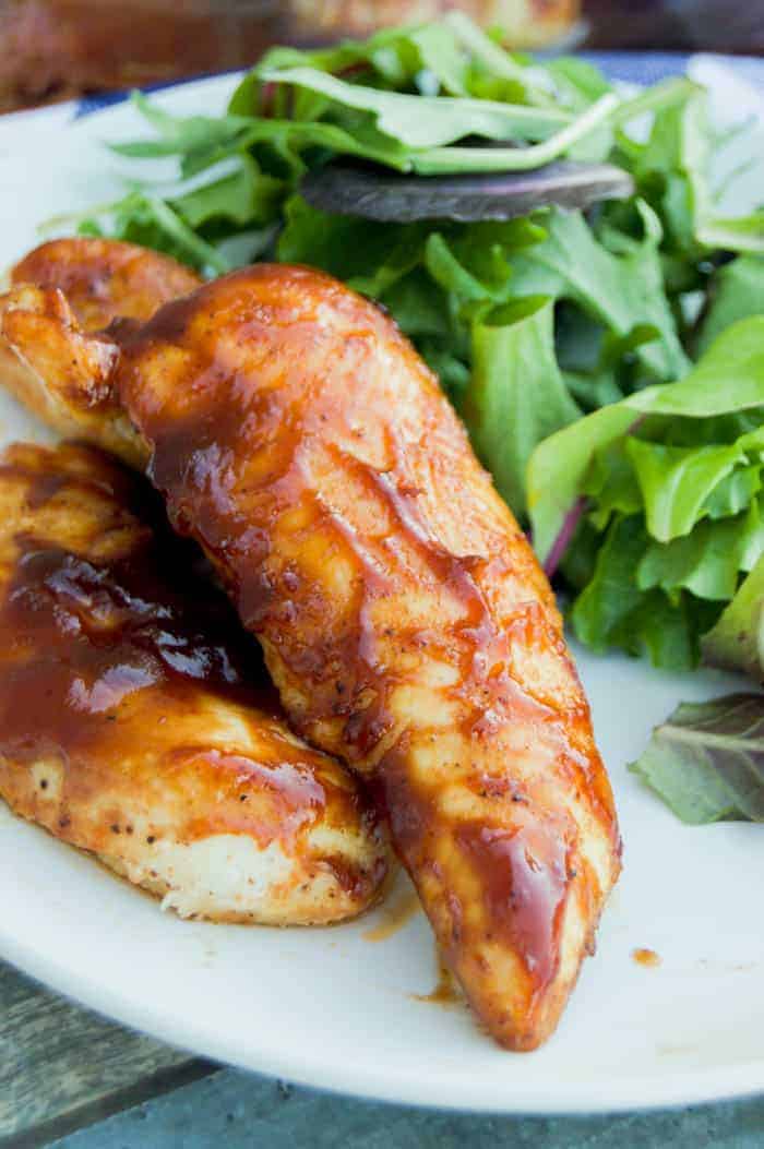 Baked BBQ Chicken Tenders on a plate with salad