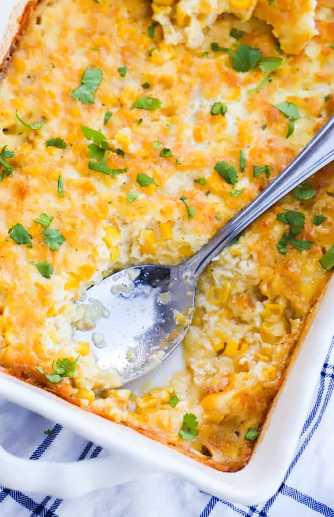 Corn Pudding being scooped out of a white casserole dish