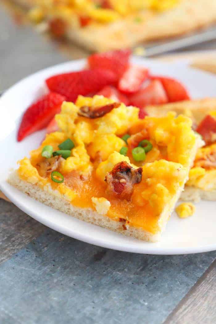 Bacon Breakfast Pizza on a white plate with berries.