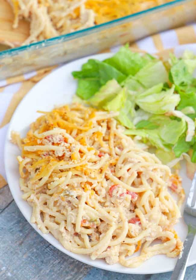 Chicken Spaghetti Casserole on a white plate with salad.