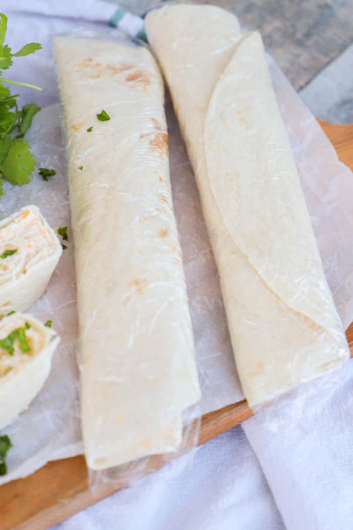 Chicken Taco Pinwheels wrapped in plastic wrap