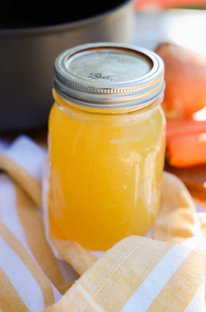 Homemade Chicken Stock with a yellow cloth napkin