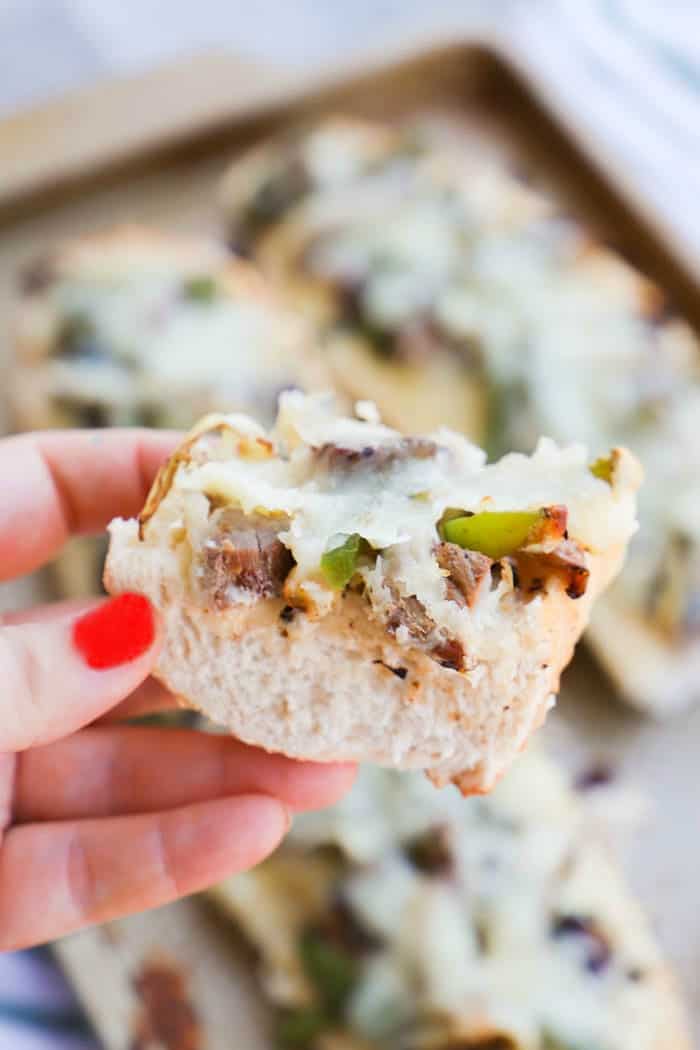 Philly Cheese Steak French Bread Pizza slice being held in a hand