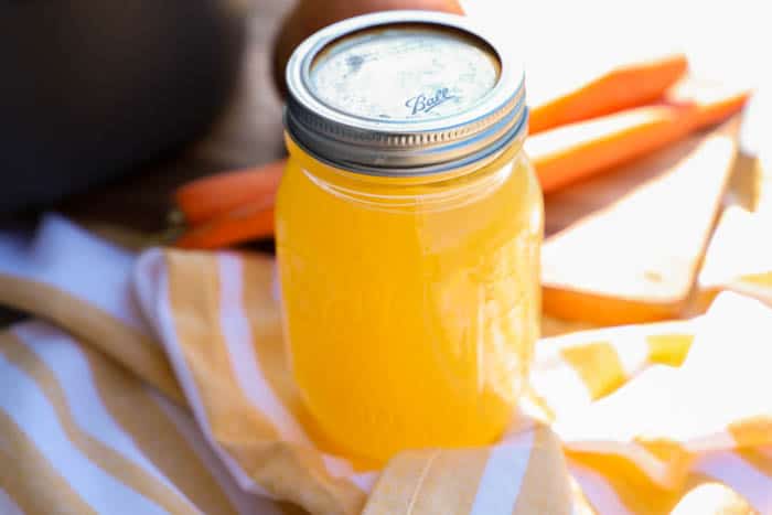 chicken stock with carrots in background