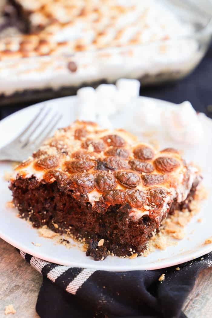 S'mores Poke Cake in a white plate with a fork