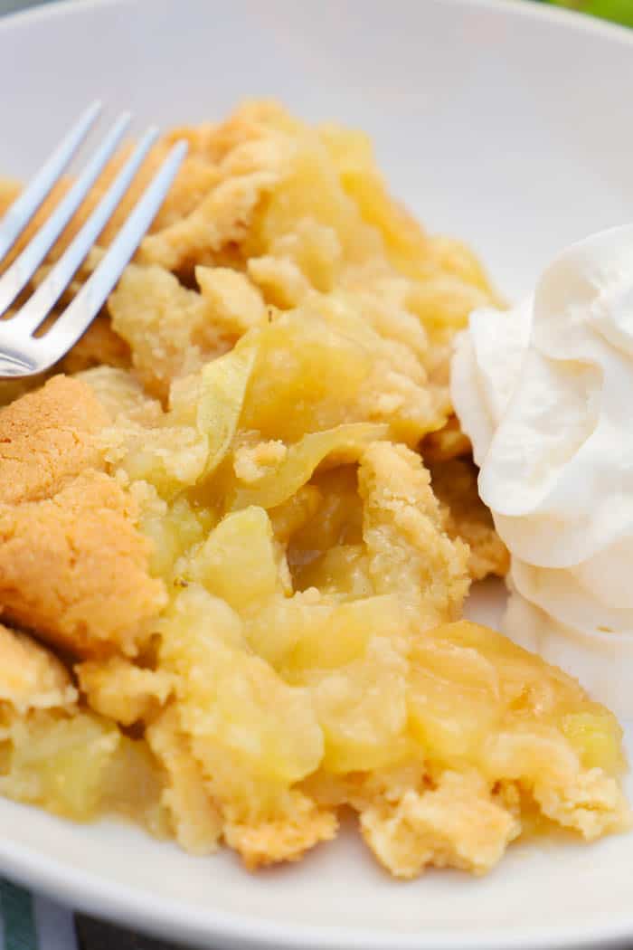 Close up Apple Cobbler with fork and whipped cream.