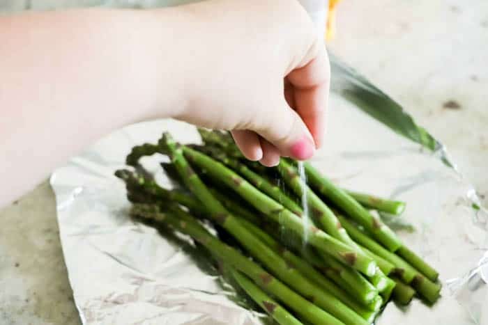 sprinkling salt on Grilled Asparagus