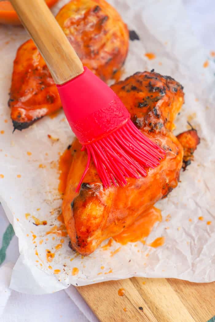 brushing on buffalo sauce to Grilled Buffalo Chicken