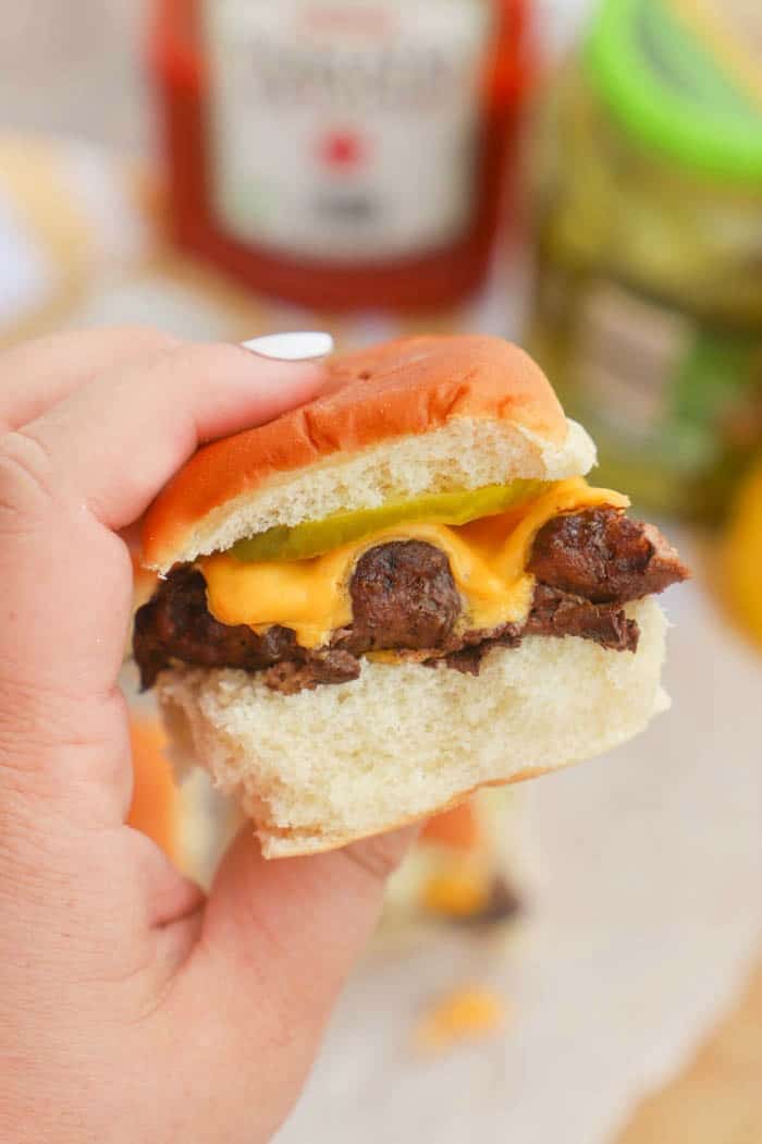 holding a cheeseburger slider