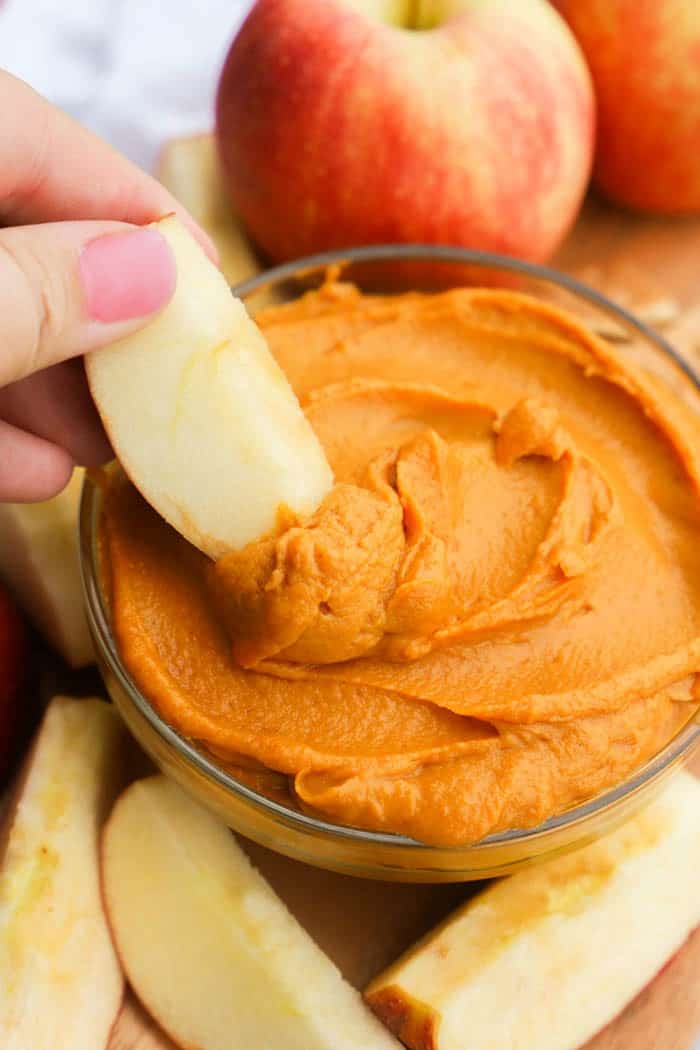 dipping an apple into Peanut Butter Pumpkin Pie Dip