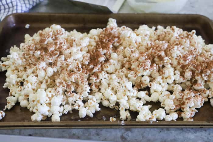 Pumpkin Spice Popcorn adding seasoning 